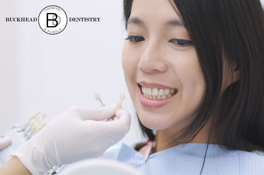 A dentist holds a dental crown option so the patient chooses the best option.